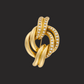 A vintage diamond brooch with a knotted design, crafted in 18k yellow gold, featuring round-cut diamonds.